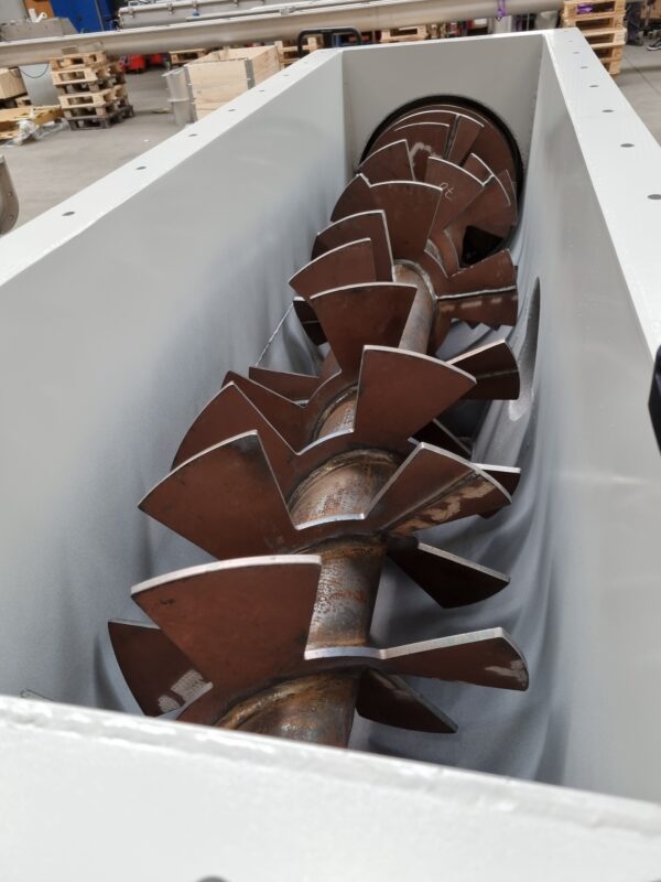 Auger with paddles in screw conveyor house